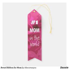 a pink ribbon with the words mom in the world on it