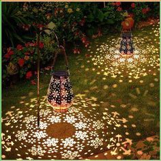 two lit up lanterns sitting in the grass