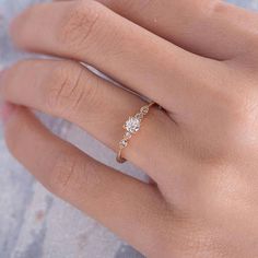 a woman's hand wearing a gold ring with three stones on it and a diamond band