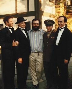 four men in tuxedos are posing for a photo