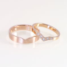 two gold wedding rings with diamond accents on white background, side by side in close up view