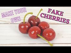 four cherries on a white wooden surface with the words make your own fake cherries