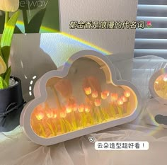 there are many candles in the shape of a cloud on this table with tulips