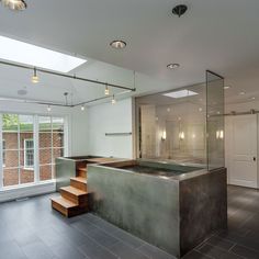 an indoor hot tub in the middle of a room with stairs leading up to it