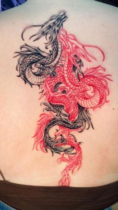 a woman's back with a dragon tattoo on it