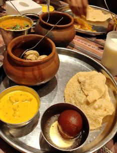 there are many different dishes on the table with soups and other foods in bowls