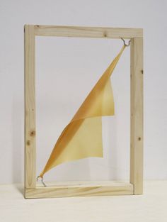 a wooden frame with a paper sail in it