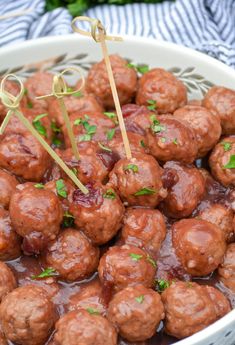 meatballs with ketchup and parsley in a white bowl