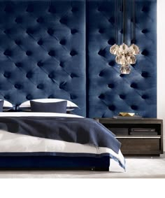 an image of a bedroom setting with blue upholstered headboard and chandelier