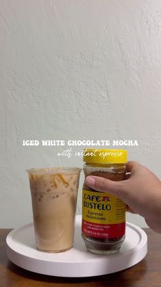 a person holding a jar of ice cream next to a drink on a plate with the caption iced white chocolate mocha