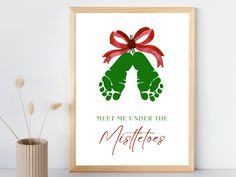 a framed poster with the words meet me under the mistletoos on it