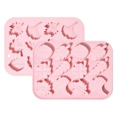 two cookie trays with different shapes and designs on the top, one is pink