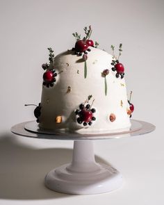 a white cake with cherries and berries on it