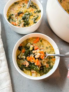 two white bowls filled with soup and vegetables