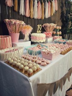 a table topped with lots of desserts and cupcakes on top of it