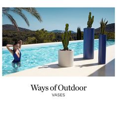 there is a woman standing in the water next to some potted cacti