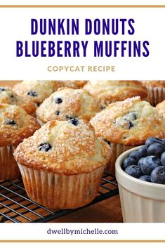 blueberry muffins with powdered sugar on top and bowl of fresh blueberries in the background