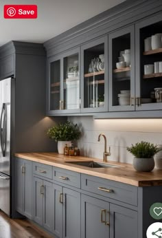 a kitchen with gray cabinets and wooden counter tops