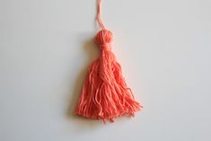 an orange tassel hanging on a white wall