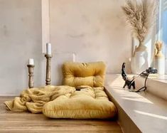 a yellow chair sitting on top of a wooden floor next to a window sill