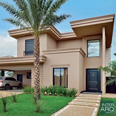 a house with a car parked in front of it and a palm tree next to it