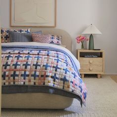 a bedroom with a bed, nightstands and pictures on the wall above it that is decorated in pastel colors