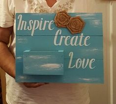 a man holding up a sign that says inspire create love and flowers on the front