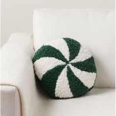 a green and white pillow sitting on top of a white couch