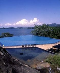 an empty swimming pool surrounded by mountains and water