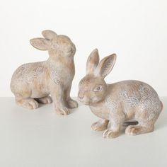 two ceramic rabbits sitting next to each other