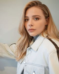 a woman with blonde hair wearing a denim jacket