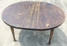 an old wooden table sitting on the sidewalk