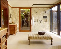 a bathroom with a bench, sink and large glass doors leading to an outside patio