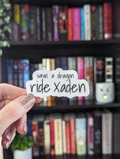 someone holding up a sticker that says save a dragon ride xaden