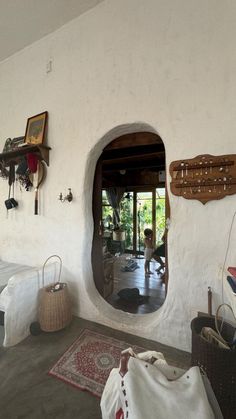 a living room with an oval window and white walls