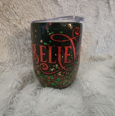 a black tumbler with red lettering and confetti sprinkles on it