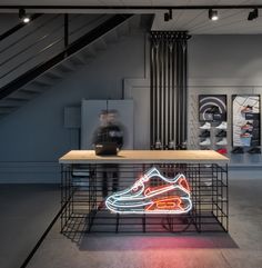 a neon shoe sits on top of a table in the middle of a room with stairs