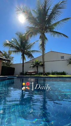 an empty swimming pool with palm trees and the sun shining in the sky behind it