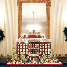 a christmas display in front of a large mirror with lights and decorations on the top