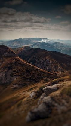 the mountains are covered in grass and clouds