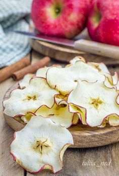 some apples are sitting on a wooden plate