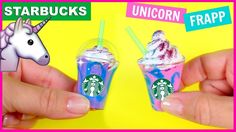 someone is holding two small cups with unicorns in them and the cup has ice cream on it