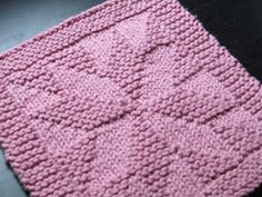 a pink knitted blanket sitting on top of a table