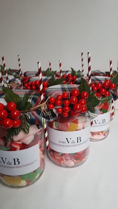 several jars filled with candy and topped with red berries