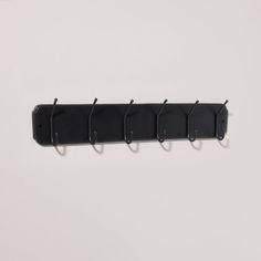 a wall mounted coat rack with five hooks