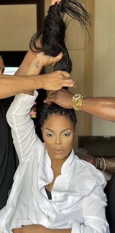 a woman getting her hair styled by another person