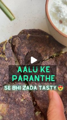 someone is pointing at some food on a plate with the words, aaluke paranthe sehi zada tasty