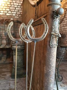 an old wooden door with metal handles and hooks on the handlebars next to it