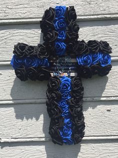 a cross made out of black and blue roses