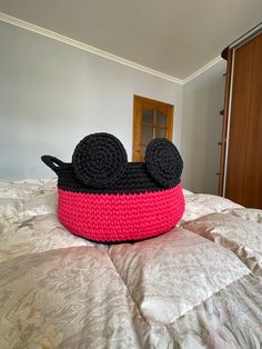 a crocheted mickey mouse pillow on top of a bed